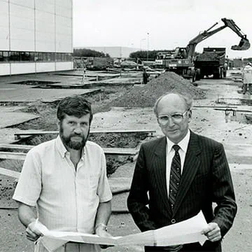 Two men holding drawing plans for new facility to represent Trelleborgs international expansion