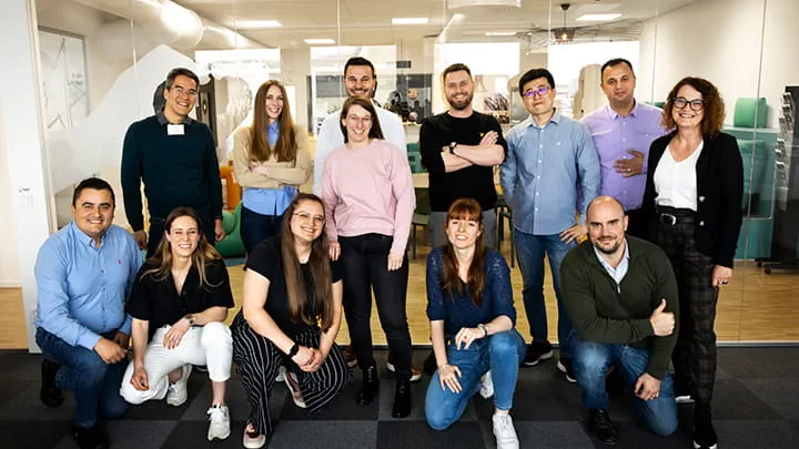 A cheerful group of Trelleborg employees poses in the campus at the headquarter, representing the company's commitment to teamwork and community.