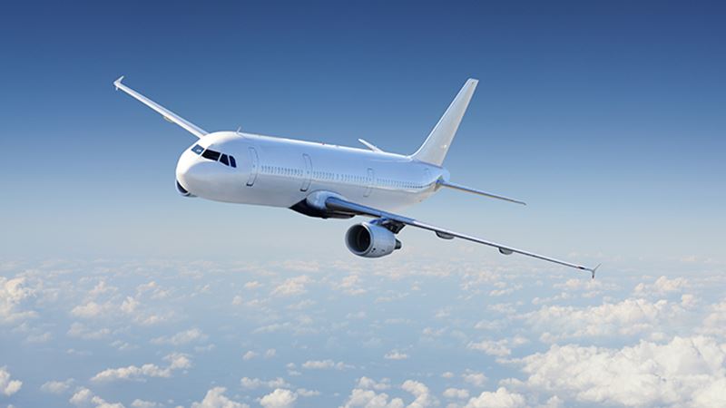 Airplane over the cloudy sky