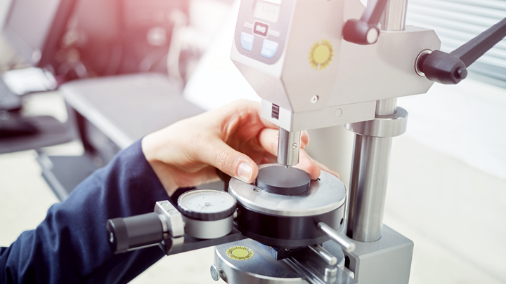 A person's hand adjusting or focusing a microscope