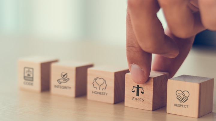 Handarrangera träklossar märkta med kod, integritet, ärlighet, etik och respekt på ett bord